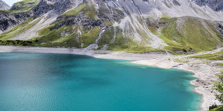An image of Dandadhar Lake with crystal-clear waters reflecting the surrounding greenery.