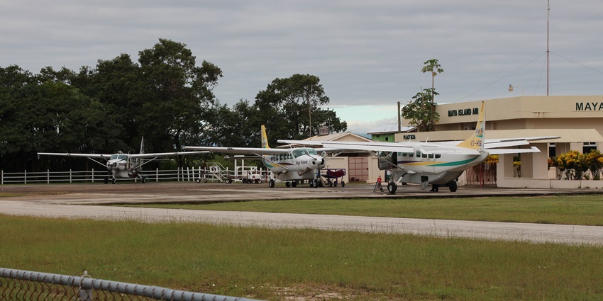 Dangriga airport with multiple propeller aircraft parked on the runway of the airport