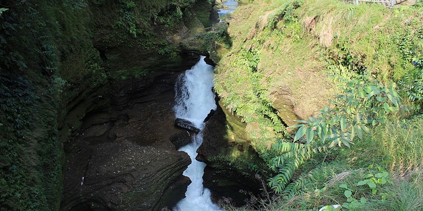 A glimpse of the cascading Davis Falls surrounded by lush green vegetation in Nepal.