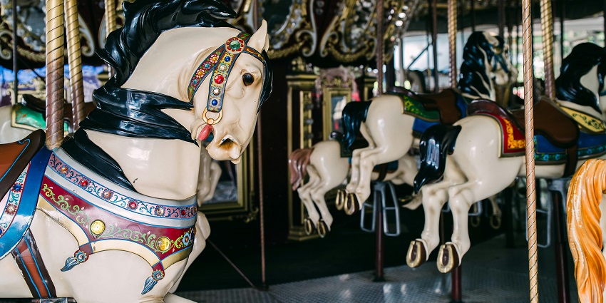 A white horse on a carousel, surrounded by colourful decorations, is a thing to do in Mahabaleshwar.