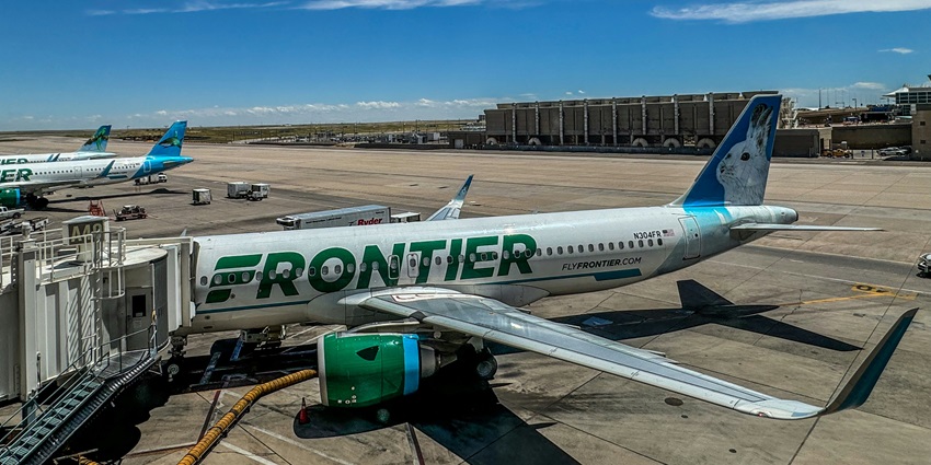 Panoramic view of Denver Airport, showing distinctive tent-like roof, runways, & flights