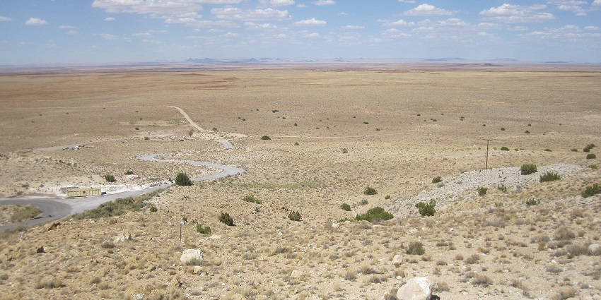 Meteor Crater in a desert covered with stones and dry grass and a narrow pathway