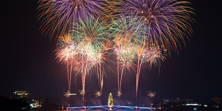 A cityscape at night with fireworks lighting up the sky in multiple locations during the Diwali.