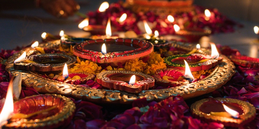 An image of a beautiful festival of Diwali in which people are lighting the candles and diyas
