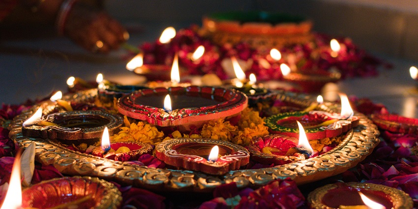 An image of a beautiful combination of diyas and candles layed out for Diwali, one of the popular Hindu festivals in India.