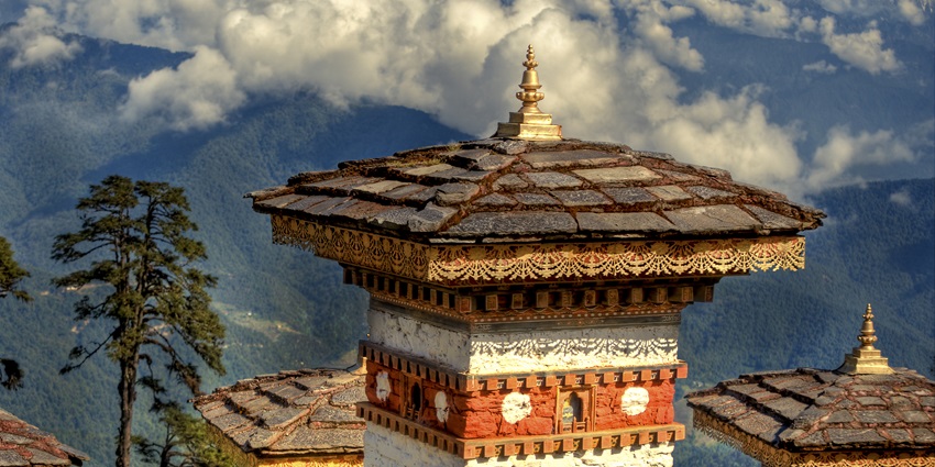 The stunning Dochula Pass in Bhutan, featuring 108 memorial chortens surrounded by a scenic mountain view.