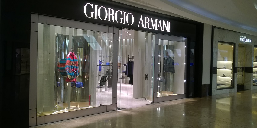 Interior of a shopping mall featuring a Giorgio Armani store with elegant lighting and displays