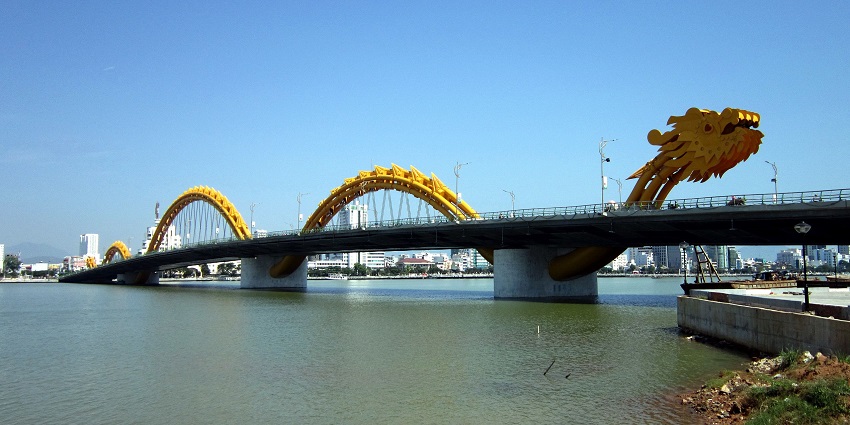 The famous Dragon Bridge in Da Nang, Vietnam, lit up at night with colourful lights.