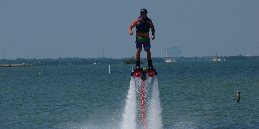 A person enjoys vibrant views of the Marina skyline while enjoying flyboarding in Dubai.