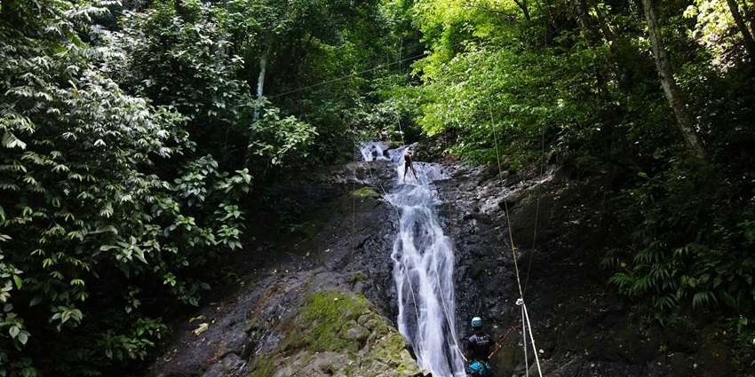 A big waterfall flowing down the rocks with a pool, one of the best trails for hiking.