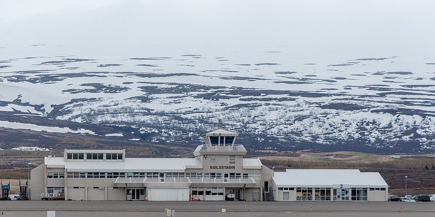 Egilsstaðir Airport terminal with east Iceland mountain range visible in the distance.
