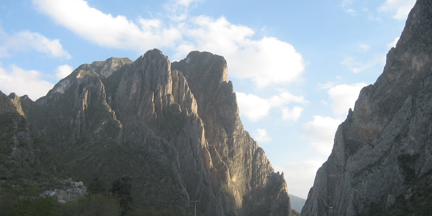 An image of a climber scaling a rugged cliff with a rope at the El Potrero Chico.