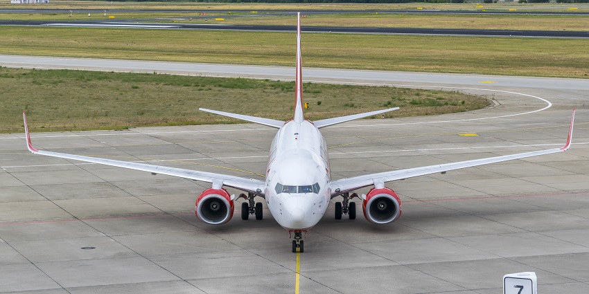 A silver colour aircraft is moving along the taxiway while aligning for departure.