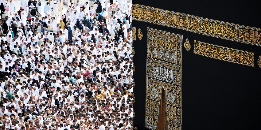 Kaaba, a black cube-shaped structure with gold embroidery, and a large crowd of people