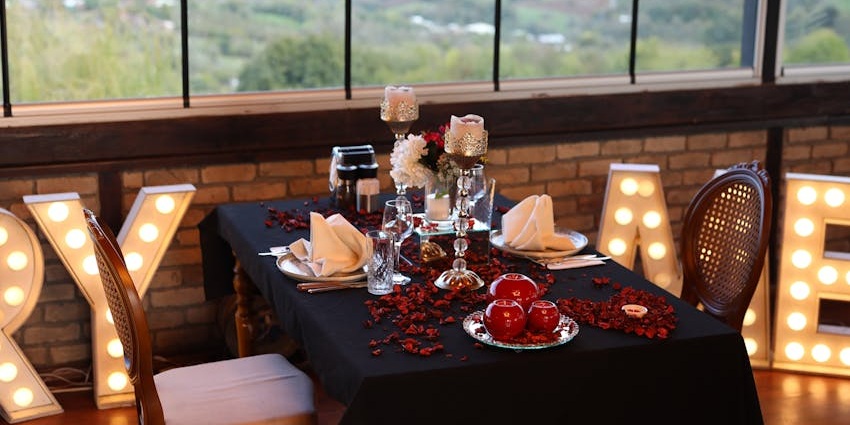 A dinner setup with a scenic view, featuring a table with elegant decor and warm lighting.