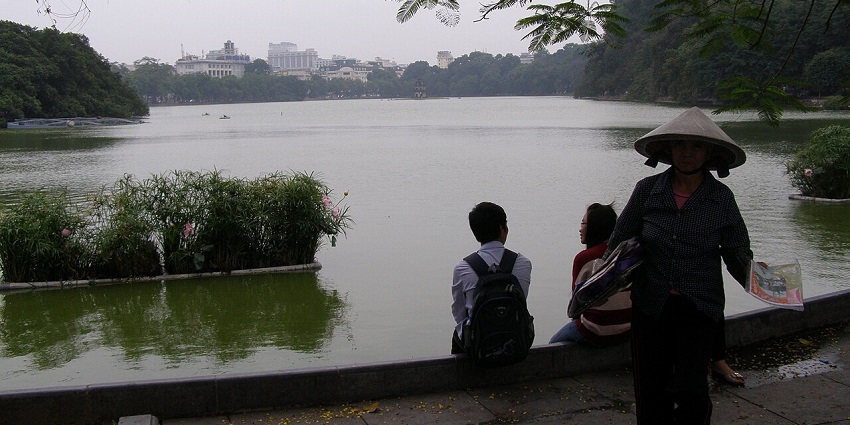 Image of a a street performer entertaining tourists near Hoàn Kiếm Lake