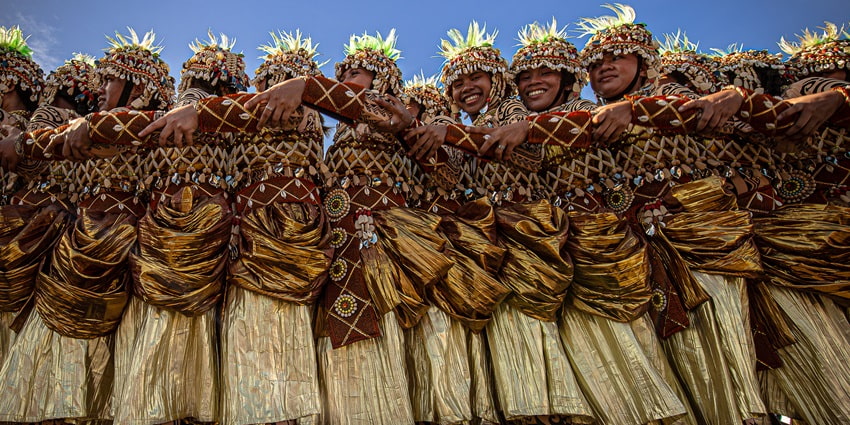 The Alotau Cultural Festival in New Guinea Island displays tribal members in striking costumes while selling handcrafted souvenirs.