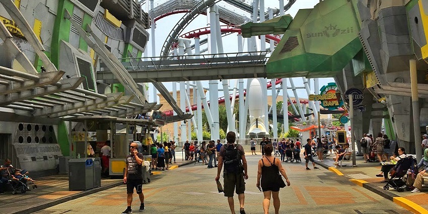 Visitors walking through the themed area at Universal Studios Singapore with rides ahead