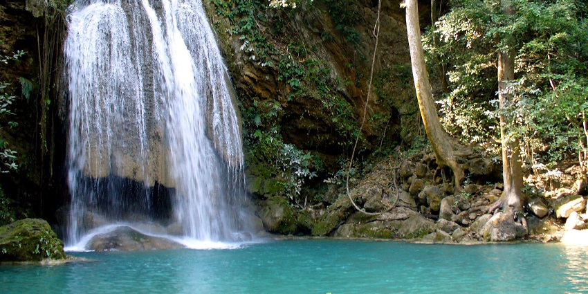 The stunning Erawan Waterfall in Kanchanaburi, Thailand, is surrounded by lush green forests.