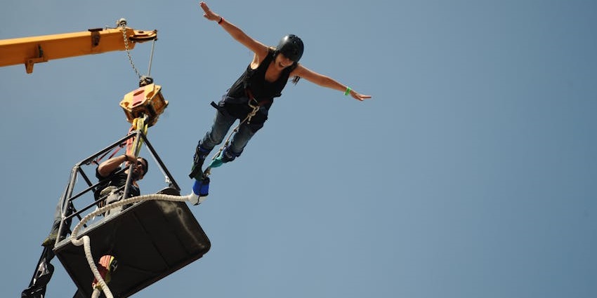 A view of the a woman bungee jumping in the mountain ranges from the Europabrucke Bridge