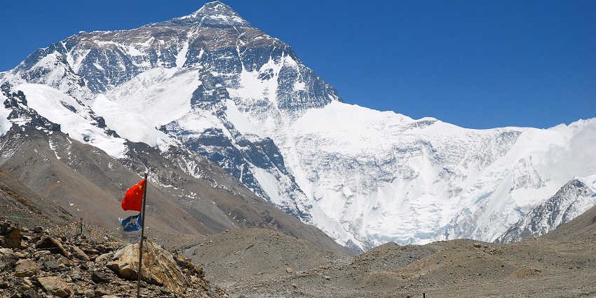 An image of Mount Everest Base Camp with tents set up on rocky terrain under a clear sky.