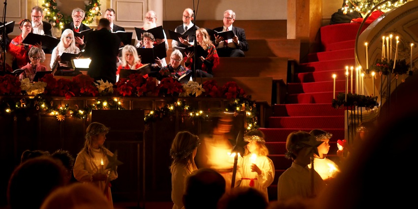 A festive candlelight concert with a choir performing with holiday decorations.