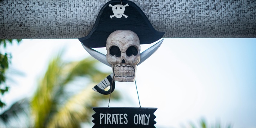 Image of a pirate sign and a skull near beach for pirate theme treasure hunt play for kids