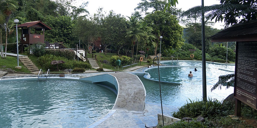 An image of curved swimming pools connected by a walkway, showcasing the Poring Hot Springs in Kota Kinabalu