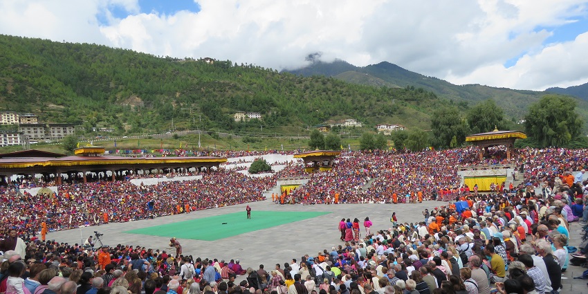 An image of a traditional dance, during the Paro Tsechu Festival with performers in colourful costumes and masks