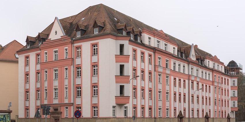 Image of a pink and white Art Deco Architecture, with dormer windows, and columns.