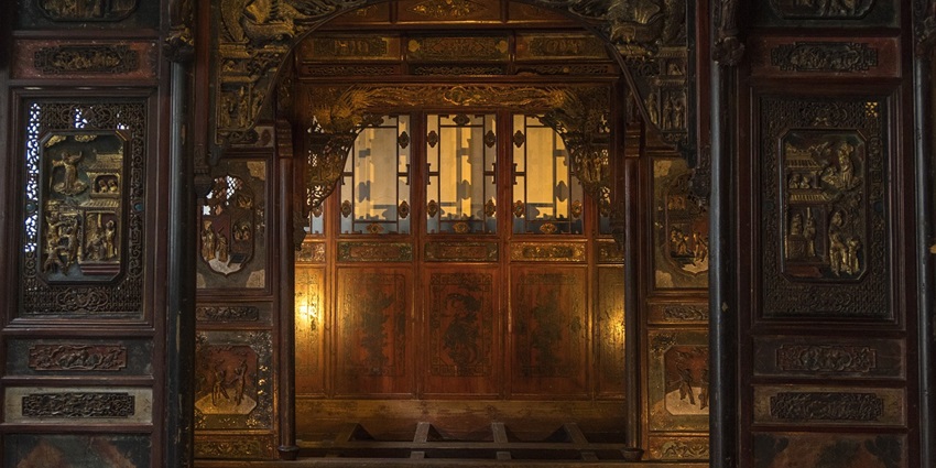 An image showing a wooden interior with intricate details, similar to Binh Thuy Ancient House.