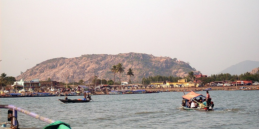A distant view of Balugaon's shoreline from the calm waters of Chilika Lake.