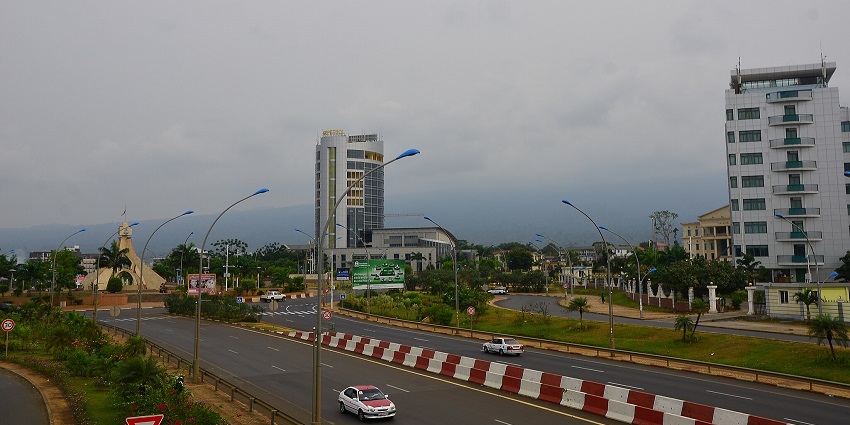 Colonial buildings standing among lush greenery and vehicles passing on the roads