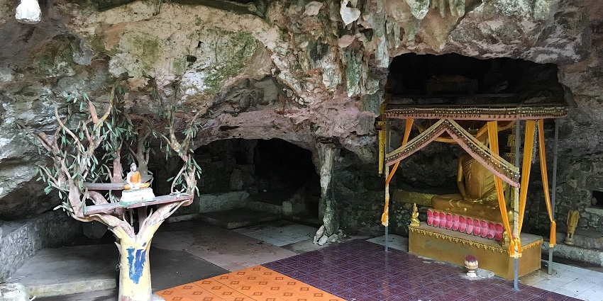 An image of an intricately designed cave interior featuring statues on pedestals, one of the best things to see in Cambodia in April.