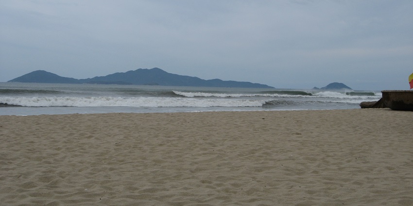 An image of the Chàm Islands showing clear blue waters and green hills in Vietnam.