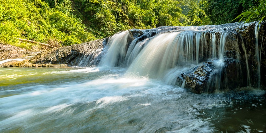 Explore Mesekelat Waterfall cascading amid lush forest, among the things to do on Palau Island.