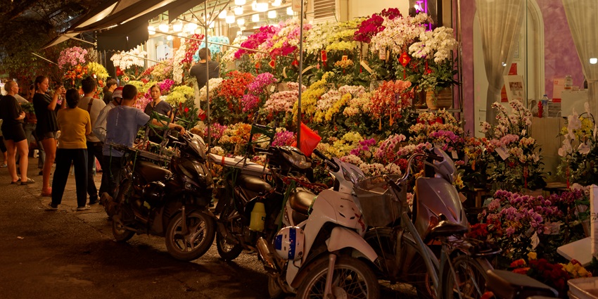 An old quarter selling rows of flower bouquets as yellow lights brighten up the place