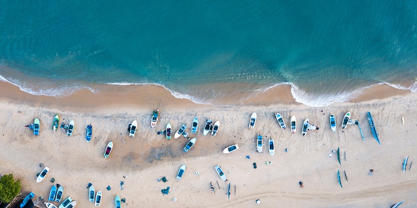 An aerial view of the turquoise-blue waters of the Pottuvil Lagoon decked with boats.