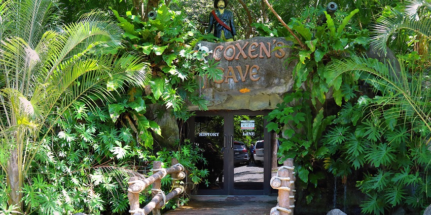 Visitors are exploring Coxen’s Cave in Gumbalimba Park, surrounded by rock formations