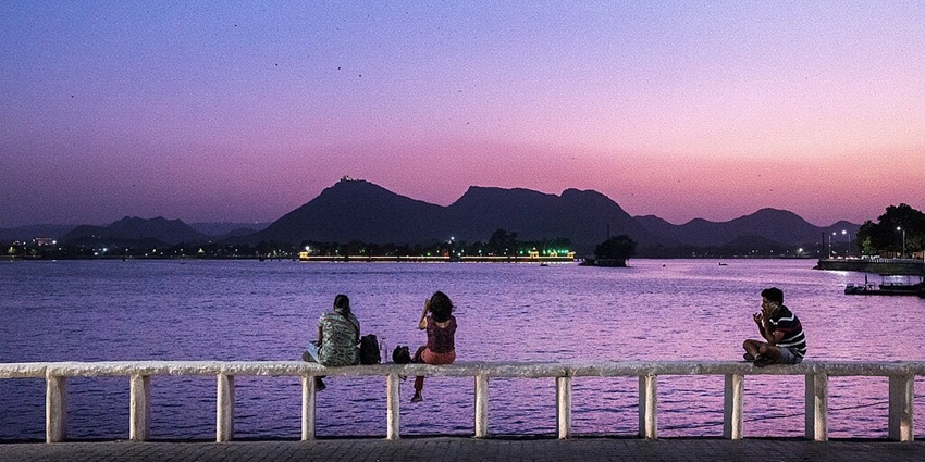 Peaceful view of Fateh Sagar Lake with boats and surrounding hills in Udaipur, Rajasthan