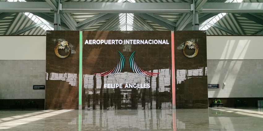 Inside Felipe Ángeles International Airport, with logo and text on a big marble wall