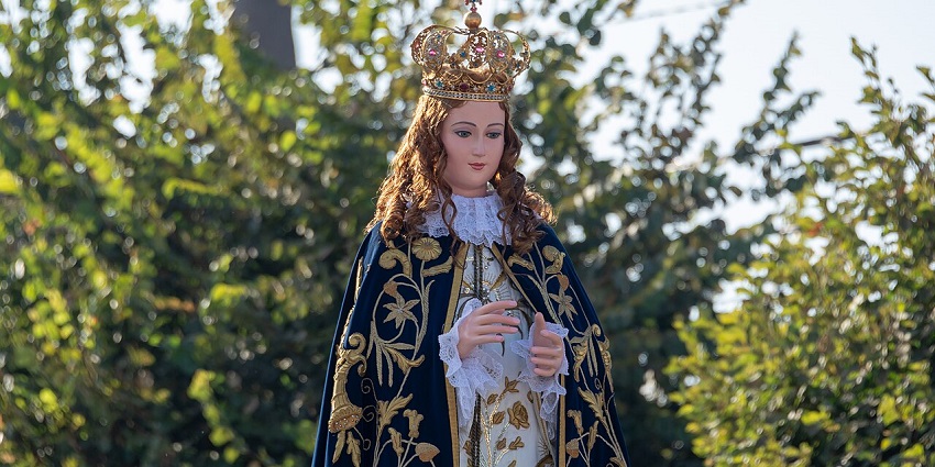 A religious procession honoring the Virgin Mary, featuring an ornate statue and devotees