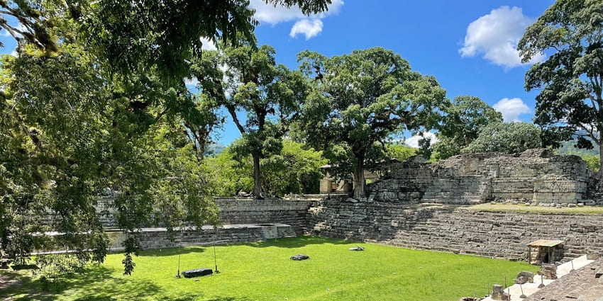The ruins of Copán stand in a lush green landscape, highlighting Mayan architecture.