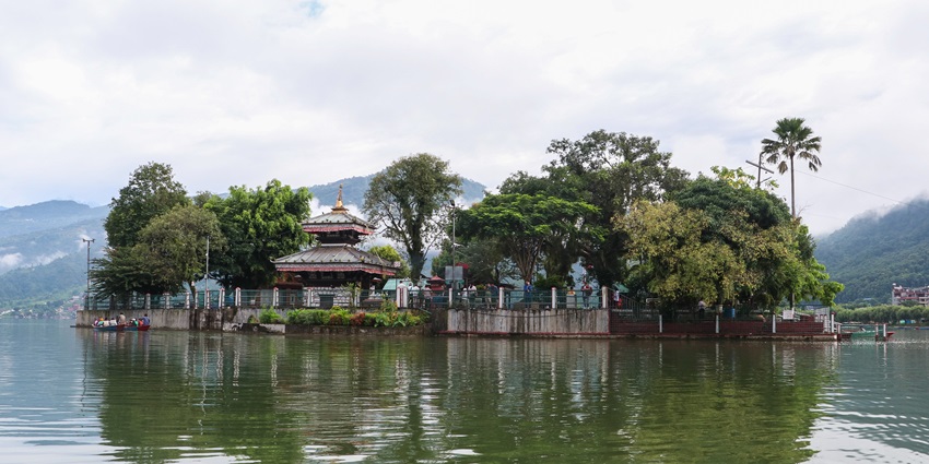 Floating island in the middle of Phewa Lake with Tal Barahi temple surrounded by greenery