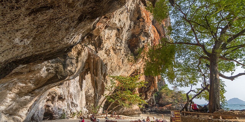 Image of Phra Nang Cave Beach with a sandy shore, limestone cliffs, and clear water.