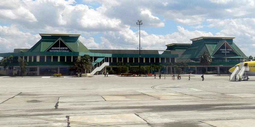 Frank País International Airport with a yellow aeroplane and passengers near the plane