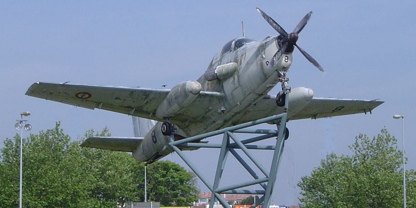 An image of a historic camouflage aircraft labeled “8,” mounted outdoors in the French Naval Aviation Museum.