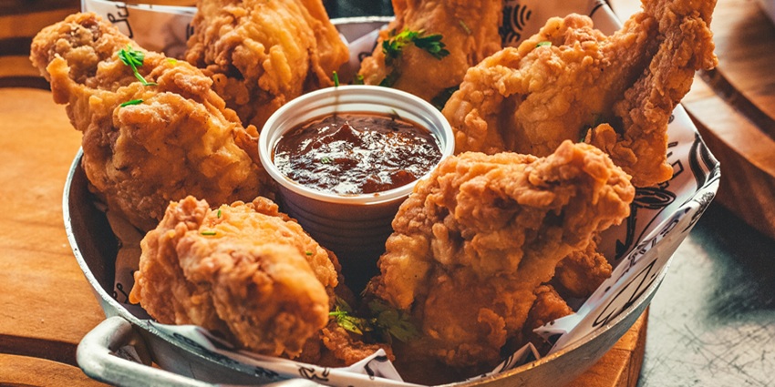 An image showing a fried chicken leg, one of the best foods you should try in the USA.