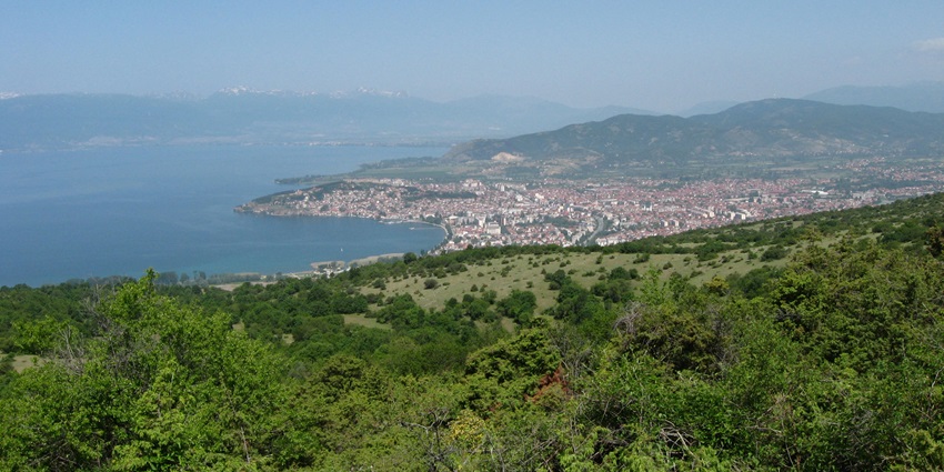 View of Lake Ohrid from Galicica National Park with mountains and blue sky.
