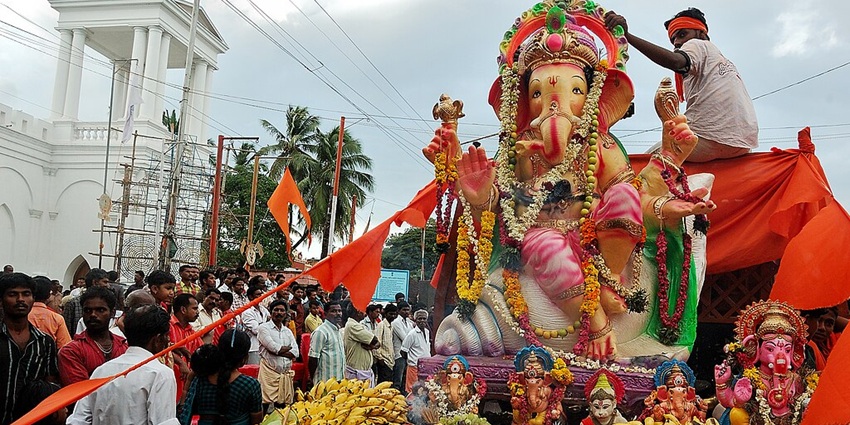 An image of Ganesh Ji decorated with ornaments and flowers outside a temple, one of the best festivals in India